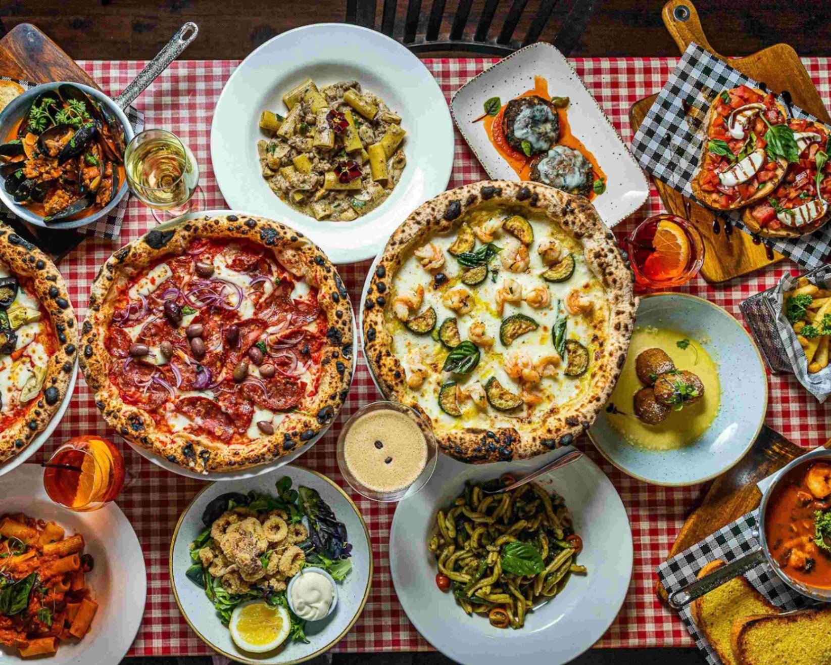 Italian pizza, pasta and antipasti spread on a red gingham tablecloth at Pizza Connect Penrith